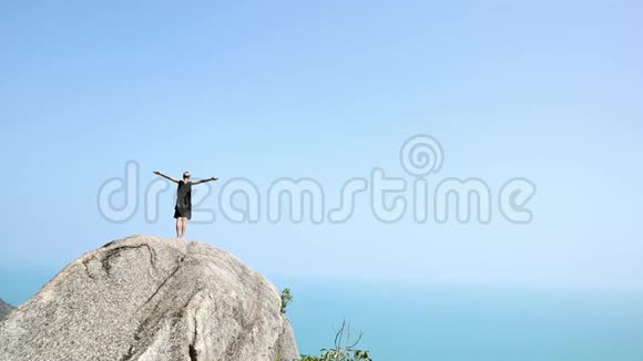 有短发的年轻女子站在悬崖边上视频的预览图