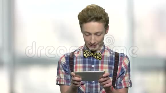 时髦的少年在智能手机上玩游戏视频的预览图