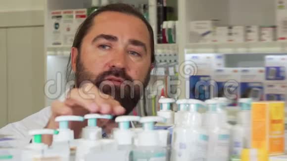 大胡子药剂师在药店工作时对着镜头微笑视频的预览图