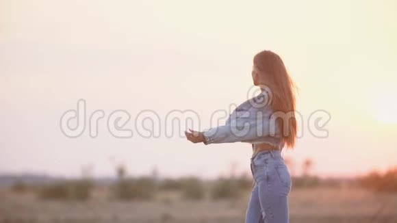 穿牛仔裤衣服的女孩在夕阳下视频的预览图