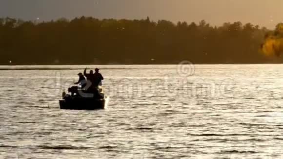日落时分渔民们在湖上的渔船上钓着几条海利派克鱼视频的预览图