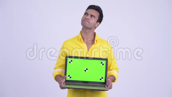 快乐的年轻印度商人一边思考一边展示笔记本电脑视频的预览图