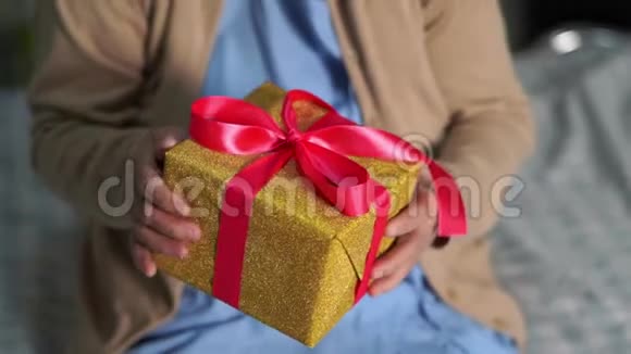 在圣诞节和新年庆祝活动中亚洲老年或老年妇女患者戴着圣诞老人助手帽子手捧礼品盒视频的预览图