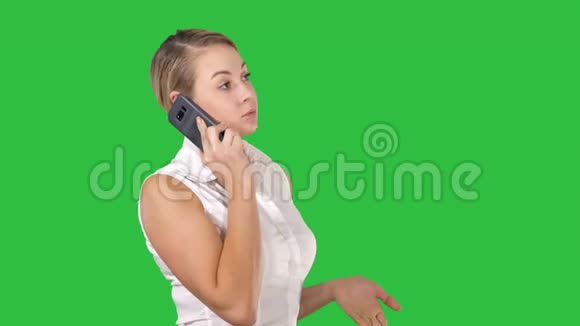 迷人的商务女性用手机打电话同时站在绿色屏幕上色度键视频的预览图