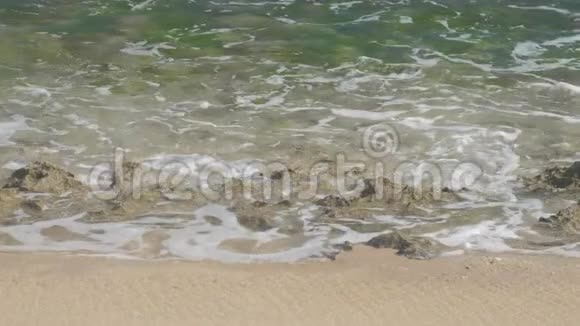 阳光明媚的海滩上海浪在石头上翻滚视频的预览图