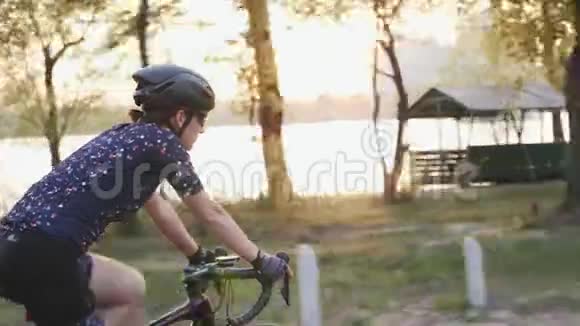 年轻女性骑自行车背景是河流城市和日落自行车的概念视频的预览图