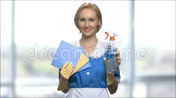 微笑的女人展示洗涤剂和抹布清洁视频的预览图