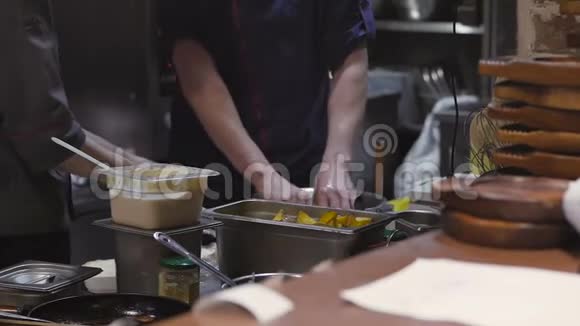 在餐厅的厨房里两位厨师准备了一道菜在框架里你只能看到他们的手视频的预览图