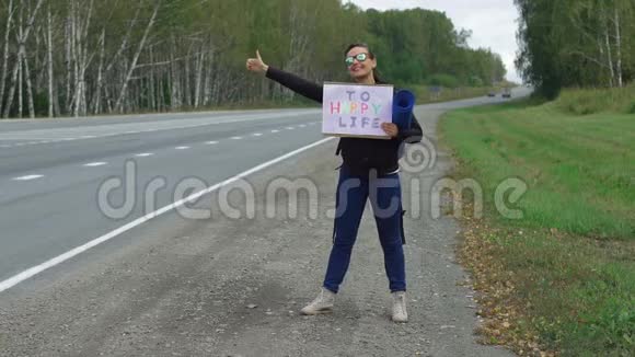 年轻女子正拿着一个纸板牌子在远足视频的预览图