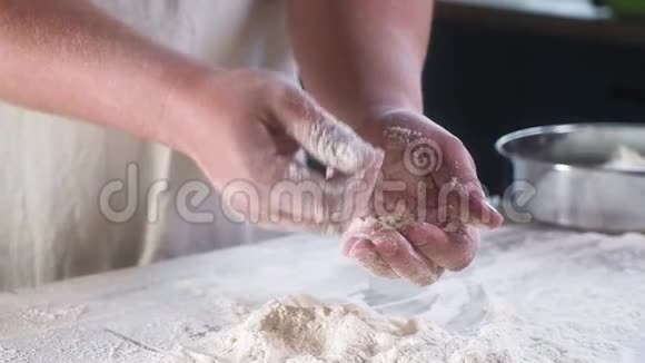 面包师傅用面粉拍了几次手洗手小麦粉把灰尘飞过桌子慢动作特写视频的预览图