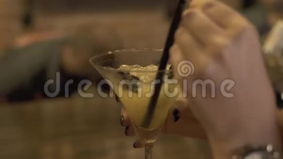 年轻女子在餐厅的酒吧柜台用吸管喝含酒精的鸡尾酒把美女关起来喝酒视频的预览图