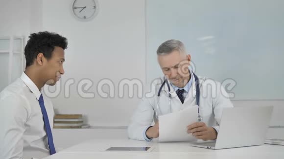 高级医生与门诊病人谈话讨论医疗报告视频的预览图