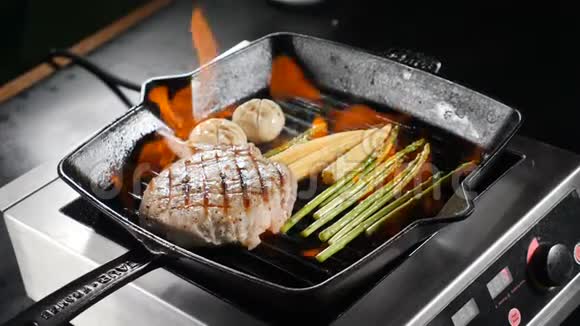 厨师在餐厅烹饪弗拉姆贝式菜肴在煎锅上蔬菜牛排用火焰炒慢动作食物视频的预览图