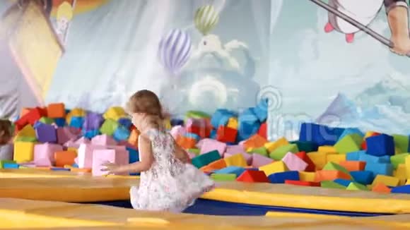 小女孩在儿童操场上蹦床上跳儿童游戏视频的预览图