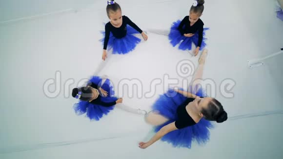 小女孩和她们的芭蕾舞老师坐着伸展身体视频的预览图