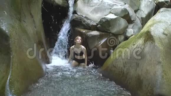 可爱的女孩慢动作溅起清澈的湖水看着用绿色的小瀑布拍摄视频的预览图