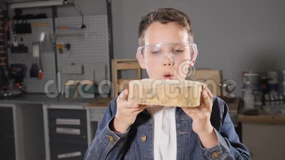 一个男孩戴着透明的眼镜缓慢地吹走锯末从事成人职业的孩子高清高清视频的预览图
