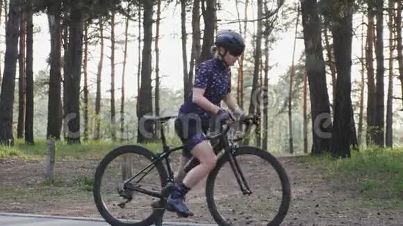 漂亮的运动女孩戴着头盔和眼镜开始她的自行车训练自行车的概念慢动作视频的预览图