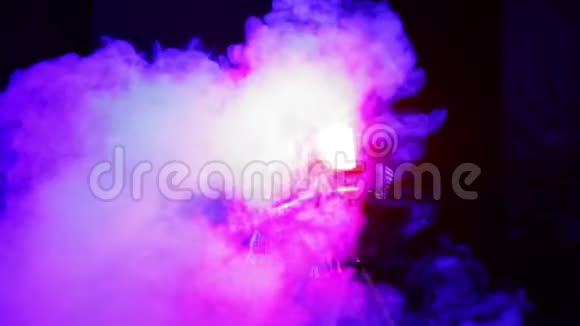 舞台上的一位年轻女子用一台用一台戏剧轮廓投影仪感应烟雾中的光线视频的预览图