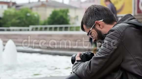 男胡子游客带着相机在公园里拍视频视频的预览图