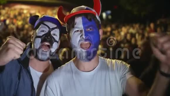 脸上有油漆的人高兴地跳起来以赢得Socer或足球比赛4k视频的预览图