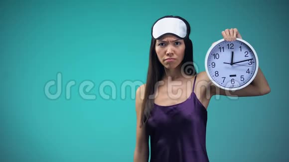睡不着的女人穿着睡衣脸上的瞎子指着时钟失眠视频的预览图