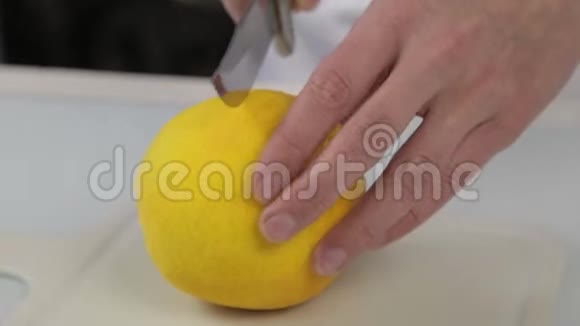 用刀切橘子的糖果师切板上的两半橙色视频的预览图
