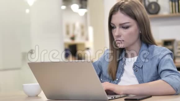 有颈部疼痛的创意女人忙着做手提电脑视频的预览图