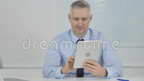 高级商人通过平板电脑在线视频聊天视频的预览图