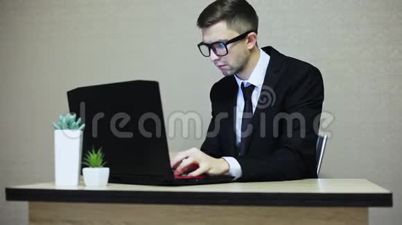 穿西装戴眼镜手提电脑屏幕反光的英俊商人视频的预览图