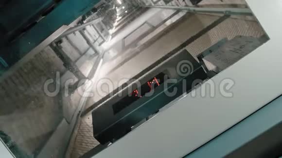 弯曲的电梯井道显示下降电梯与玻璃透明顶部通过该机构是视频的预览图