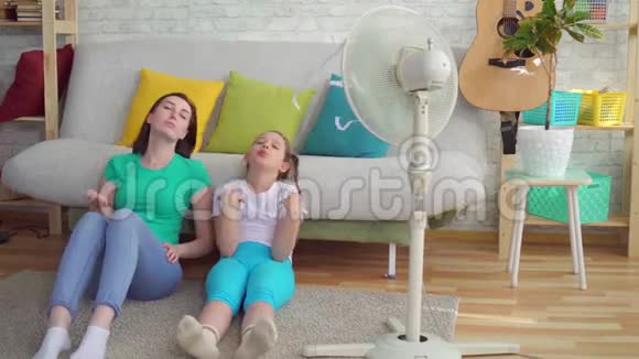 风扇旁边的母女遭受着炎热的天气视频的预览图
