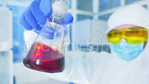 化学实验室穿着防护服的科学家分析实验室烧瓶中的液体视频的预览图