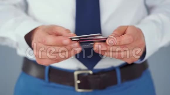 穿着正式服装的男士从几张信用卡中挑选一张视频的预览图