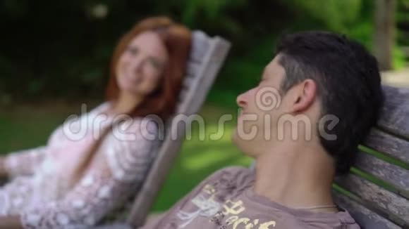 阳光明媚的一天男人和女人坐在丛林的露台上视频的预览图