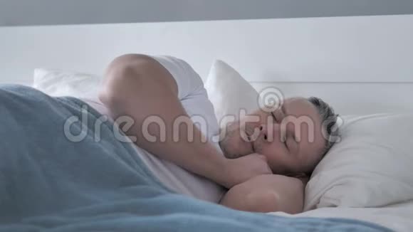 疲惫的白发男子与颈部疼痛睡床视频的预览图