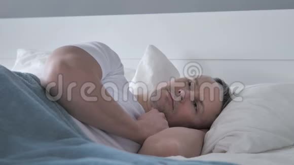 躺在床上思考的白发男人视频的预览图