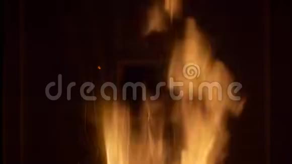 在砖壁炉中拍摄温暖舒适燃烧的火的特写视频黑色背景视频的预览图