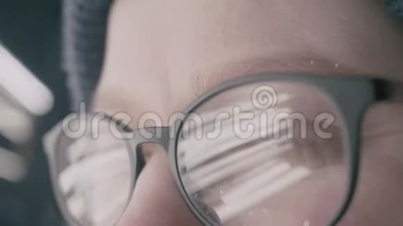 女孩带着眼镜眼睛看着相机极端的特写和反射视频的预览图