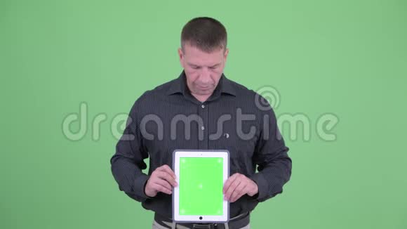 马乔成熟的商人展示数字平板电脑视频的预览图