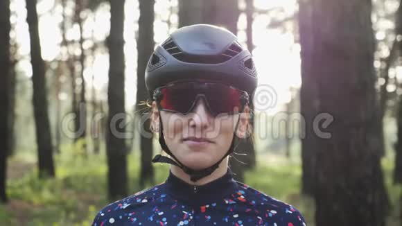 漂亮的年轻白种人女人戴着黑色头盔和运动衫戴上自行车眼镜三项全能概念视频的预览图