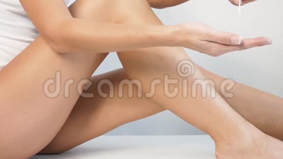 有完美身材的女人在腿上涂上清爽的奶油或身体乳液概念脱毛护肤化妆品视频的预览图