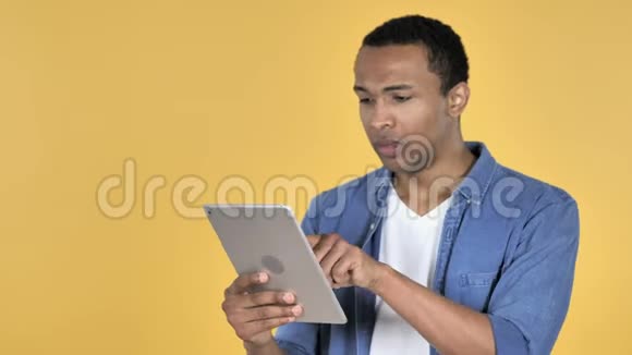 沮丧的非洲男人在震惊时使用平板蓝色背景视频的预览图