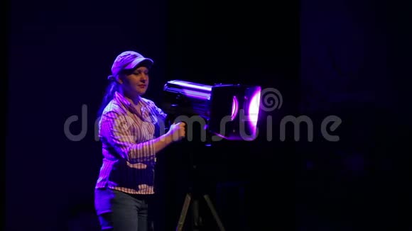 舞台上的一位年轻女子用一台一台戏剧放映机将烟雾中的光线引燃视频的预览图