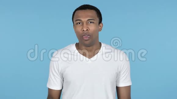 非洲青年男子伸展身体蓝色背景视频的预览图