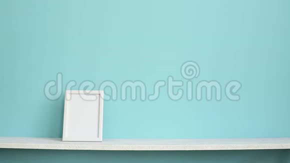 现代客房装饰与相框模型白色架子搭在青绿色的墙上用手放盆栽兰花视频的预览图