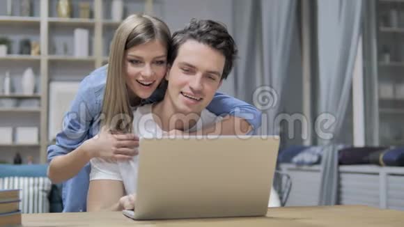 在家使用笔记本电脑的一对幸福的年轻夫妇视频的预览图