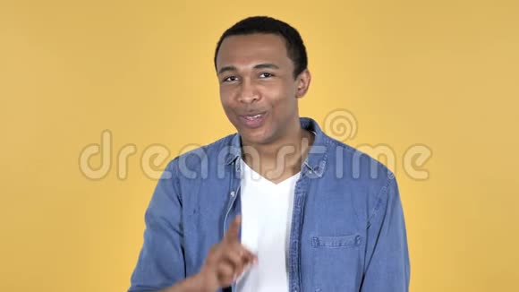 非洲青年男子沉默嘴唇手指黄色背景视频的预览图