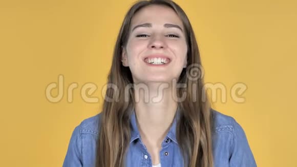黄色背景下孤独的笑话中笑的美女视频的预览图