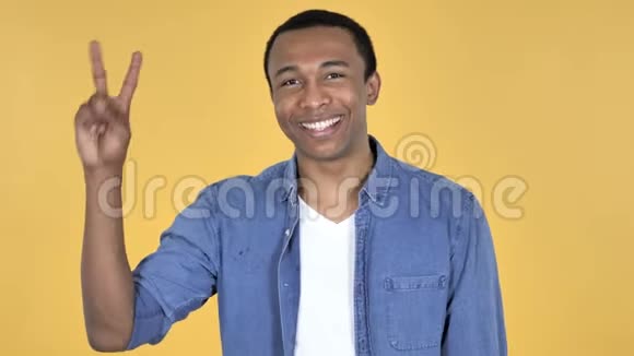 非洲青年的胜利标志黄色背景视频的预览图